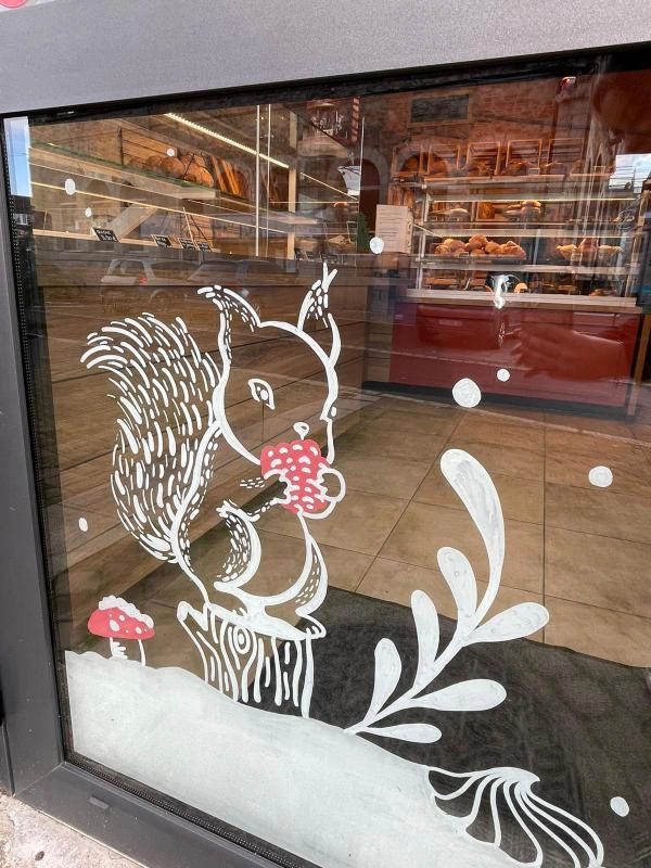 Peinture sur vitrine pour la boulangerie-pâtisserie Les Délices de Callac par la graphiste Mélanie appéré